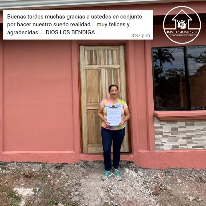 Cliente sosteniendo los documentos de su casa frente a la fachada nueva